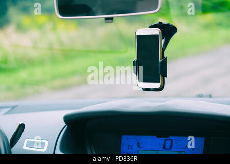 Smart phone in the car holder on the windshield Stock Photo