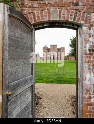 View through wall garden door to exterior facade of Whithurst Park. Stock Photo