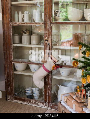 Rustic glass fronted display cabinet full of table and glassware Stock Photo