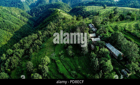 Luonan. 7th Aug, 2018. Aerial photo taken on Aug. 7, 2018 shows the slate buildings amongst trees in the Qinling Mountains in Jin'an Village at Shipo Township of Luonan County, northwest China's Shaanxi Province. The ancient slate building complex in the Qinling Mountains, also called 'daziliang' by local people, is recognized as 'a living fossil of ancient folk houses in Qinling Mountains'. Credit: Tao Ming/Xinhua/Alamy Live News Stock Photo