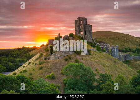 Corfe Castle, Dorset, UK.  8th August 2018.  UK Weather.  A dramatic sunrise at the ruins of Corfe Castle in Dorset.  The sunrise was soon obscured by a thickening band of cloud which produced light showers shortly after.  Picture Credit: Graham Hunt/Alamy Live News