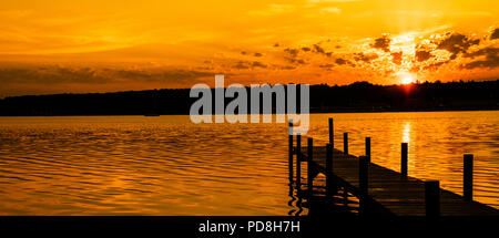 Berlin, Germany. 08th Aug, 2018. The sun rises over the large Wannsee lake, into which a jetty rises. Credit: Paul Zinken/dpa/Alamy Live News Stock Photo