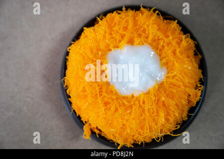 close up Top view Gold Egg Yolk Thread Cakes, or  'Cake Foi Tong' Thai cake isolated on brown cork table background with copy space Stock Photo