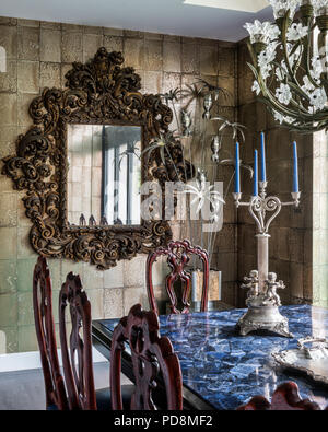 Carved folate mirror with lead crystal Baccarat chandelier above dining table in London home Stock Photo