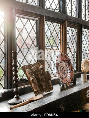 Decorative plate and ornaments on leaded glass windowsill Stock Photo