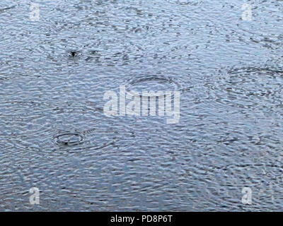Raindrops falling into a lake in the South of France. Slight showers finally appeared in August during the heatwave of 2018 in France Stock Photo