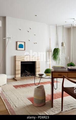 Low circular 1950’s Bellvue coffee table, 50’s Italian desk and onyx fireplace Stock Photo