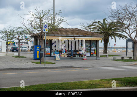 Alghere,Italy,12-April-2018:Man is looking in a street kisok shop for souvenir, paper or magazine in Alghero,Alghero is a big city in the west of the italian island of Alghero and also the airport Stock Photo
