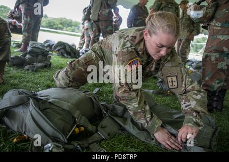 U.S. Army Staff Sgt. Charli Boyer, assigned to the Aerial Delivery and Field Services Department, U.S. Army Quartermaster School, prepares a parachute for the next day's jump during Leapfest at the University of Rhode Island, West Kingston, R.I. Aug. 4, 2018, August 4, 2018. Leapfest is the largest, longest standing, international static line parachute training event and competition hosted by the 56th Troop Command, Rhode Island Army National Guard to promote high level technical and esprit de corps within the International Airborne community. (U.S. Army photo by Sgt. Josephine Carlson). () Stock Photo