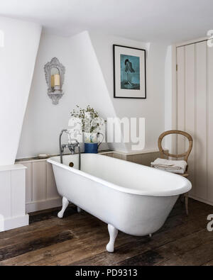 Free standing bath in attic bathroom with recycled wall panelling Stock Photo
