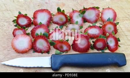 Single Strawberry on a bed of reshy picked Blackberries Stock Photo