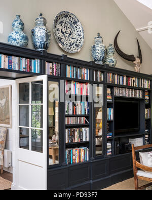 Blue and white pots on top of Farrow and Ball Downpipe, painted book shelves Stock Photo