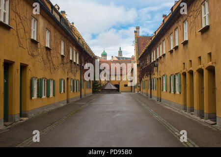 Fuggerei in Augsburg Bavaria Germany oldest social settlement in the world yellow simple attached houses donated by Jacob Fugger Stock Photo