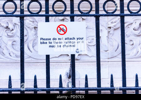 Railings warning cyclists not to chain bicycles to them, otherwise they will be locked away. Stock Photo