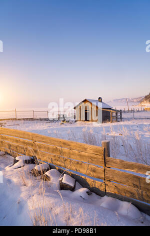 Traditional Russian wooden architecture in Siberia. House of logs with blind window shutters and fence. Irkutsk. Russia. Stock Photo