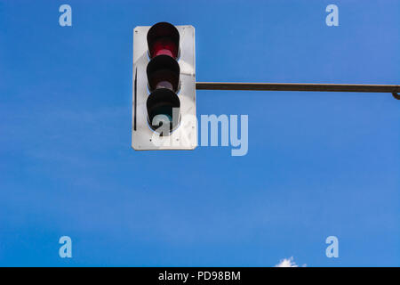 A traffic light and a surveillance camera on a pole mounted on the street. Stock Photo