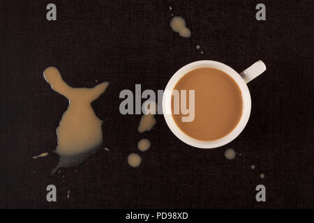 Coffee cup and spilled coffee on a dark background from above. Stock Photo