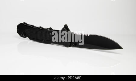 Tactical knife. Black knife spring assist spring loaded weapon. Serrated knife on white background. Stock Photo