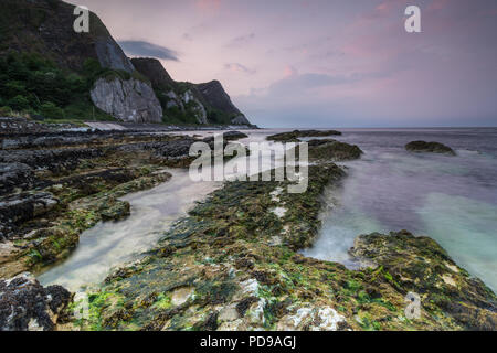 Rocky coastal view at sunset, Garron Point, County Antrim, Northern Ireland. Stock Photo