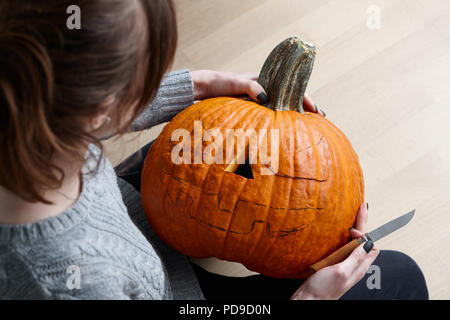 Carving halloween pumpkin into jack-o-lantern, close up view Stock Photo