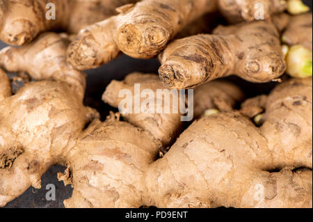 Whole ginger roots on dark old stone background table top view space for text. Stock Photo
