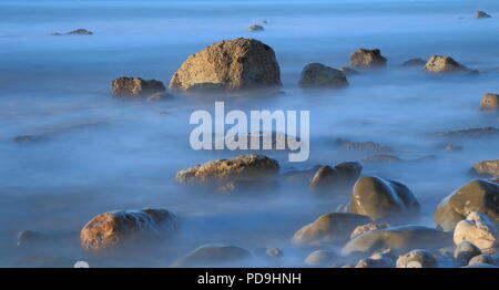 Blurred sea waves on the shingle beach in Devon on the Jurassic Coast Stock Photo