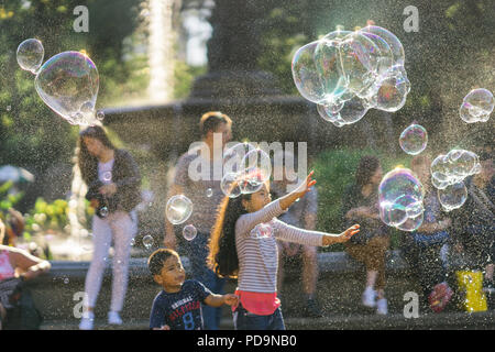 New York City, United States - September 24, 2016. Giant rainbow soap bubbles floating in the summer air during a beautiful sunny day. Stock Photo