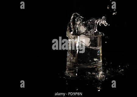 Glass with drink splash along with copy space Stock Photo