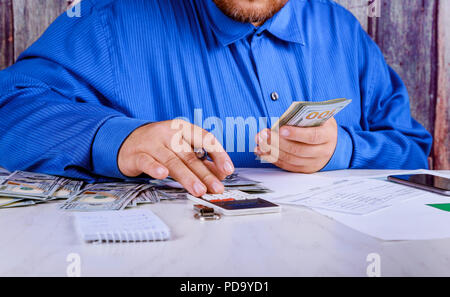 Cropped of bookkeeper using calculator money US dollars banknote money for business investment counting Stock Photo