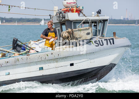 The Solent, Hampshire, UK; 7th August 2018; A Fisherman Guts a Fish Whilst Aboard a Small Fishing Boat at Sea Stock Photo