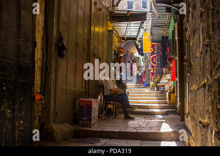 11 May 2018 An Islamic man waiting for custom outside his small shop in a narrow side street off the Via Dolorosa in Jerusalem Israel Stock Photo