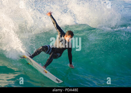 Surfer performing a cutback on a small right-hand wave Stock Photo