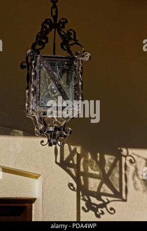 Carriage lamp style outdoor light covered in cobwebs to catch the insects attracted by the light Stock Photo