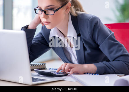 Female finance professional working on keyboard with reports Stock Photo