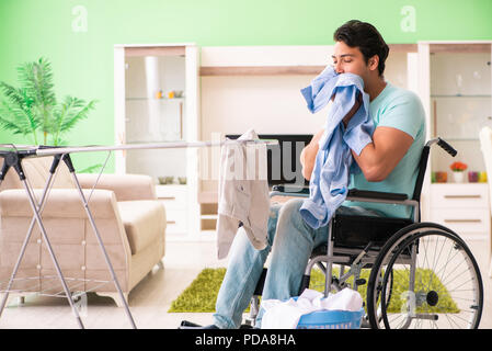 Disabled man on wheelchair doing laundry Stock Photo