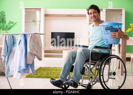 Disabled man on wheelchair doing laundry Stock Photo