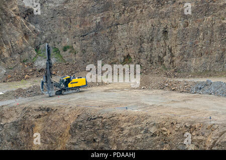 Opencast mining quarry with mining drilling machine. Mining in the granite quarry. Mining industry. Stock Photo