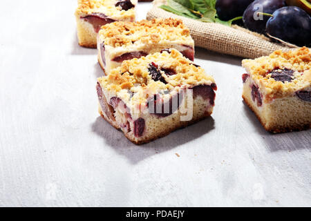 Rustic plum cake on wooden background with plums around Stock Photo