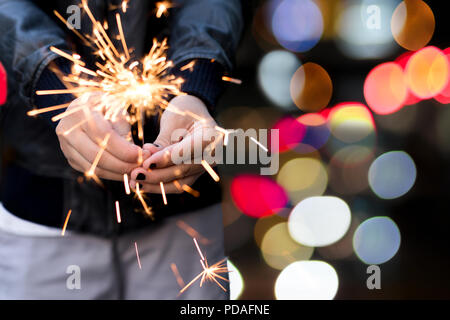Yiung girl holding a sparkle with bokeh light in background. Stock Photo