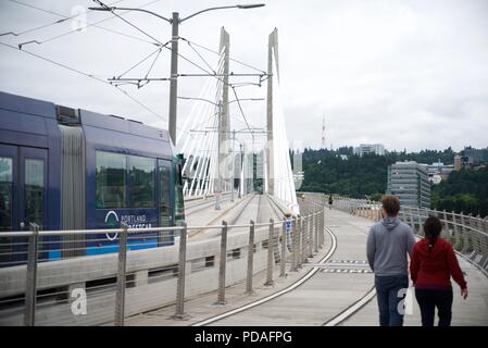 PORTLAND, OREGON, MAY 16 2017, On the Tilikum Crossing bridge with a Streetcar, people walking & jogging across the span. Stock Photo