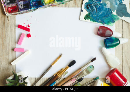 painting mockup.blank sketchbook, paintbrushes and paints on yellow wooden  board background. Creative artist workplace flat lay. top view on table  with Blank notebook with drawing tools. Stock Photo