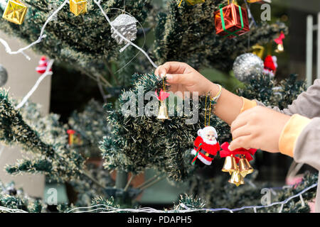 Little boy helping decorate Christmas tree with christmas decoration. Stock Photo