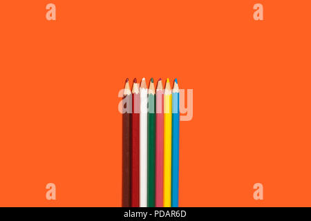 line of colored pencils on the orange background Stock Photo