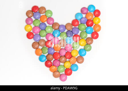 Sugar coated candies aranges in the shape of a heart isolated on a white background Stock Photo