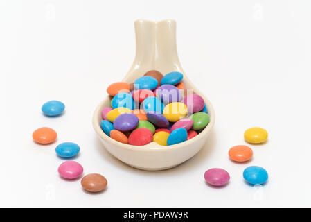 Multi-colored smarties candies on a china spoon isolated on a white background Stock Photo