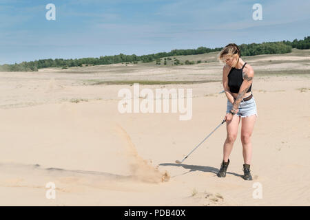 Woman is hitting with a golf club
