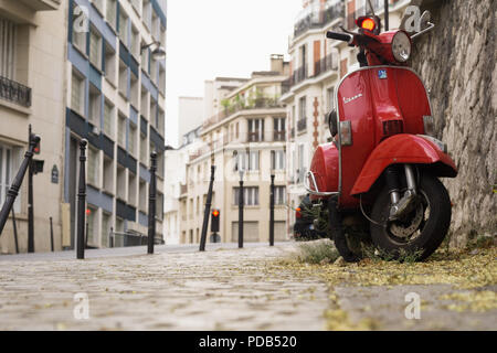Paris Vespa motor scooter - Red Vespa parked on a street in the 16th arrondissement in Paris, France, Europe. Stock Photo