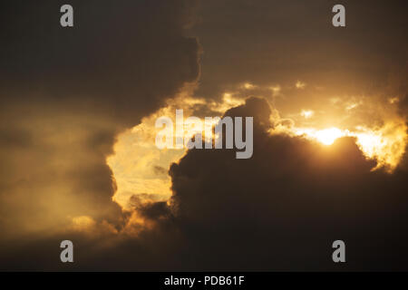 A low sun shining through clouds at dusk, Ambleside, Lake District, UK. Stock Photo