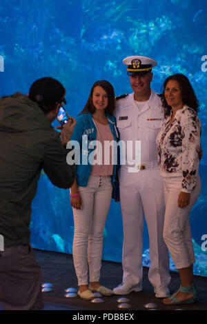 180802-N-SH284-0106 SEATTLE (August 02, 2018) Lt. Brandon Korter, a Navy Region Northwest chaplain poses for a photo with visitors at the Seattle Aquarium, where the Naval Station Everett dive locker presented a static display, during the 69th annual Seafair Fleet Week. during the 69th annual Seafair Fleet Week. Seafair Fleet Week is an annual celebration of the sea services wherein Sailors, Marines and Coast Guard members from visiting U.S. Navy and Coast Guard ships and ships from Canada make the city a port of call. (U.S. Navy photo by Mass Communication Specialist 2nd Class Vaughan Dill/Re Stock Photo