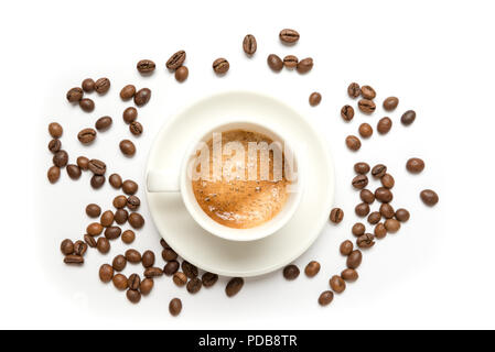 White china espresso cup viewed from above on white background with brown roasted coffee beans overflowing Stock Photo